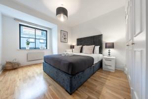 a bedroom with a large bed and a window at Holborn & Central London with Balcony - CityApartmentStay in London