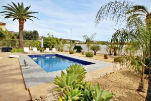 una piscina en un patio con palmeras en Golondrina - panoramic hillside holiday house in Moraira, en Moraira