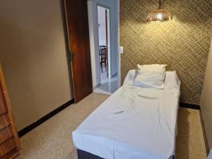 Cama pequeña en habitación con lámpara de araña en Maison le murier, en Aubignan