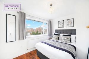 a bedroom with a bed and a window at Cosy 3-Bedroom Serviced House with Free WiFi and Parking By Redwood Stays in Farnborough +18 photos