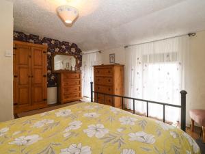 a bedroom with a bed and a dresser and a window at Bod Feurig in Caernarfon