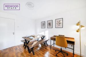 a dining room with a table and a yellow chair at Cosy 3-Bedroom Serviced House with Free WiFi and Parking By Redwood Stays in Farnborough