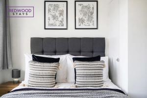um quarto com uma cama com duas almofadas em Cozy 3 Bed House with X2 FREE Parking By REDWOOD STAYS em Farnborough