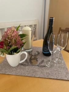 a table with a bottle of wine and two wine glasses at Hansenbauernhof in Ruhpolding