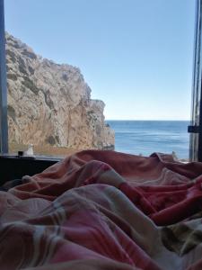 a bed with a view of the ocean from a window at Belyounech studio location de vacance in Tétouan
