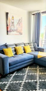 a blue couch with yellow pillows in a living room at Departamento Concepcion III in Concepción