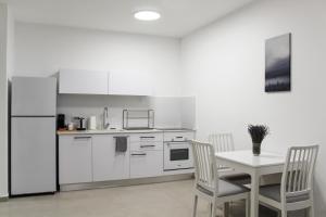 埃拉特Luxury Suite Apartment With Sea View #54 By Hashdera Eilat的白色的厨房配有桌子和冰箱