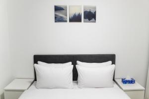 埃拉特Luxury Suite Apartment With Sea View #54 By Hashdera Eilat的一间白色的卧室，配有黑色的床头板和白色的枕头