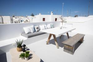 a table and bench on the roof of a house at Chiara Mykonos III in Mýkonos City