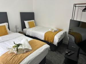 um quarto de hotel com duas camas com toalhas em KYOTO HOUSE CENTRAL DERBY I SPACIOUS, WARM & NEW with NETFLIX em Derby