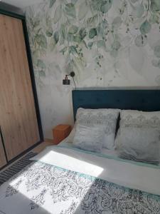 ein Schlafzimmer mit einem Bett mit Blumentapete in der Unterkunft Domek Zgredek in Żywiec + 19 Fotos