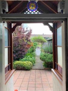 an open door to a garden with a pathway at Harvel Cottage in Paulton