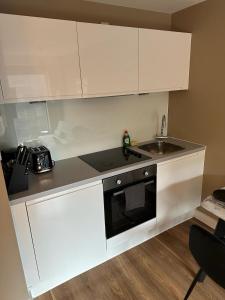 a white kitchen with a sink and a microwave at Luxury Studio Apartment by Central Stay in Liverpool