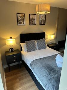 a bedroom with a bed with two night stands and two lamps at Luxury Studio Apartment by Central Stay in Liverpool