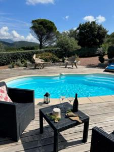 a swimming pool with a table and a chair and a table sidx sidx at Les Villas de Petra Grossa in Figari