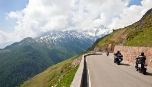 two people riding motorcycles on a road in the mountains at Hotel Jagdschloss Resort in Kühtai
