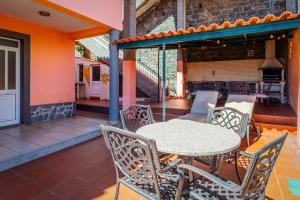 un patio al aire libre con mesa y sillas en Tranquil Oasis: 3 BR Sea View Villa with Lush Yard en Funchal