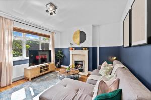 a living room with a couch and a fireplace at Lovely 3 Bed in the heart of Windsor - Garden in Windsor