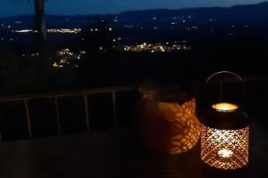 una lámpara iluminada sentada en un balcón por la noche en Casa Benucci Oliveta Tuscany, en Pulicciano