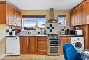 a kitchen with wooden cabinets and a stove top oven at Lovely 3 Bed in the heart of Windsor - Garden in Windsor