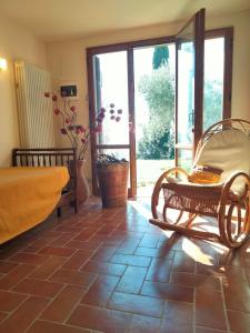 Habitación con sofá y silla en el suelo de baldosa. en Casa Benucci Oliveta Tuscany, en Pulicciano