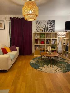 uma sala de estar com um sofá e uma mesa de centro em Paris-Versailles-Cosy-Calme-WIFI em Paris