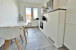 een keuken met een tafel en een witte koelkast bij Air Apartments 13 in Bremen