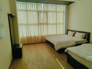 a bedroom with two beds and a large window at Hotel ananya fairview in Khātu