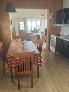 kuchnia i salon ze stołem i krzesłami w obiekcie Ytri Árbakki w mieście Hvammstangi