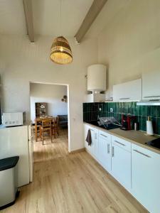 una cucina con armadi bianchi e una sala da pranzo di Appartement 2 chambres vue sur lac marin à Barcarès a Le Barcarès