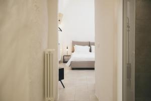 a white bedroom with a bed and a radiator at Mediterranee Suite in Lecce