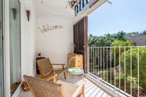 un balcón con sillas y una señal de bienvenida en la pared en La Saltarelle par Dodo à Cassis, en Cassis