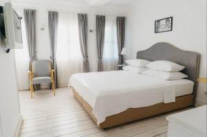 a bedroom with a large white bed with white pillows at Vintage Hotel Alacati in Alaçatı
