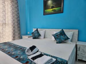 a blue bedroom with a bed with blue walls at homeystay urbandream service apartment in Faridabad