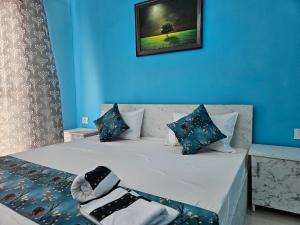 a bedroom with a bed with blue walls at homeystay urbandream service apartment in Faridabad