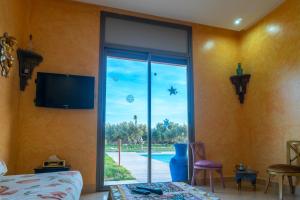 1 dormitorio con puerta corredera de cristal y vistas a la piscina en Villa Marrackech Sbai en Oubadine