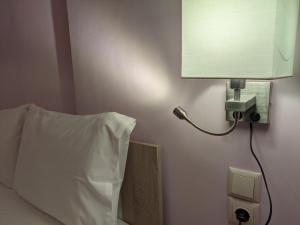 a lamp on a wall next to a bed at Aristo Central Apartments in Ioannina