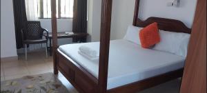 a bedroom with a bed and a desk and a chair at PALM SEA LUXURY HOMESTAY - SEBULENI APARTMENTS - Nyali Mombasa in Mombasa