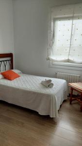1 dormitorio con 1 cama con manta blanca y ventana en Casa José, en Monte