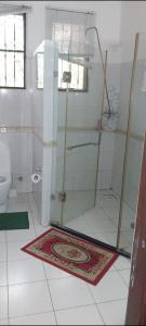 uma casa de banho com um chuveiro e um WC. em PALM SEAVIEW LUXURY HOMESTAY - SEBULENI APARTMENTS - Nyali Mombasa em Mombaça