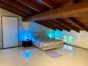 VILLA CAMPESTRE في Colombaro: غرفة نوم بها سرير مع أضواء زرقاء