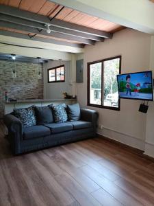 ein Wohnzimmer mit einem Sofa und einem Flachbild-TV in der Unterkunft La Amistad agrotourism farm in Penonomé