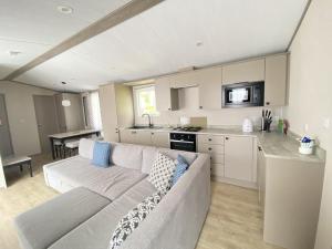 a living room with a couch and a kitchen at Linnhe Lochside Holidays in Corpach