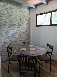 einen Tisch und Stühle in einem Zimmer mit Ziegelwand in der Unterkunft La Amistad agrotourism farm in Penonomé