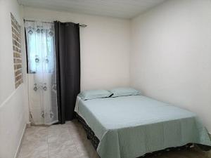 Dormitorio pequeño con cama y ducha en La Amistad agrotourism farm en Penonomé