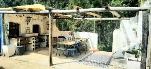 een buitenkeuken met een tafel en stoelen in een huis bij Guesthouse & Mini camping Yuccasa in Pombal
