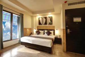 a bedroom with a large bed and a large window at Saltstayz Thyme - New Friends Colony in New Delhi