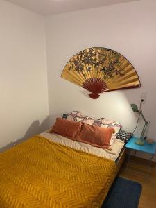 um quarto com uma cama e uma grande ventoinha na parede em Paris-Versailles-Cosy-Calme-WIFI em Paris