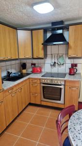 a kitchen with wooden cabinets and a stove top oven at Ferienhaus Kleinmoellerchen in Neu Poserin