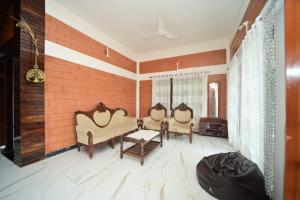 a living room with two chairs and a table at V stays in Kushālnagar